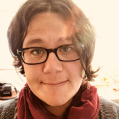 Dawn Alam wearing glasses, maroon scarf and sweater