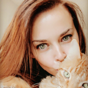 Kaitlyn Milligan with brown hair hugging her orange cat