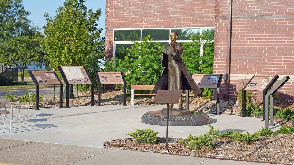 A wide view of the interpretive panels, benches, and statue making up the Dr. Lulu Merle Johnson Plaza.