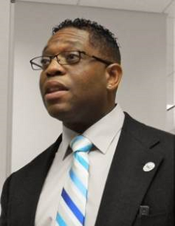 Alton Poole years later wearing a suit and blue striped tie