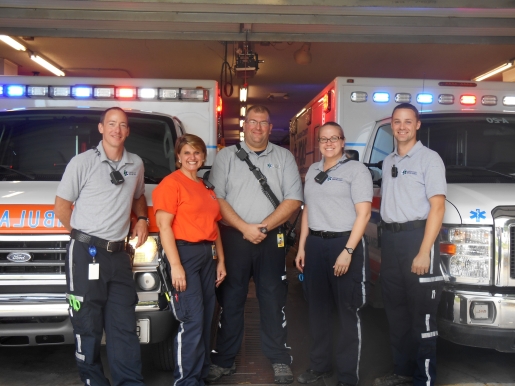 Ambulance employees standing in front of ambulance