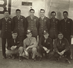Charles Goodrich standing with fellow soldiers in front of a plane