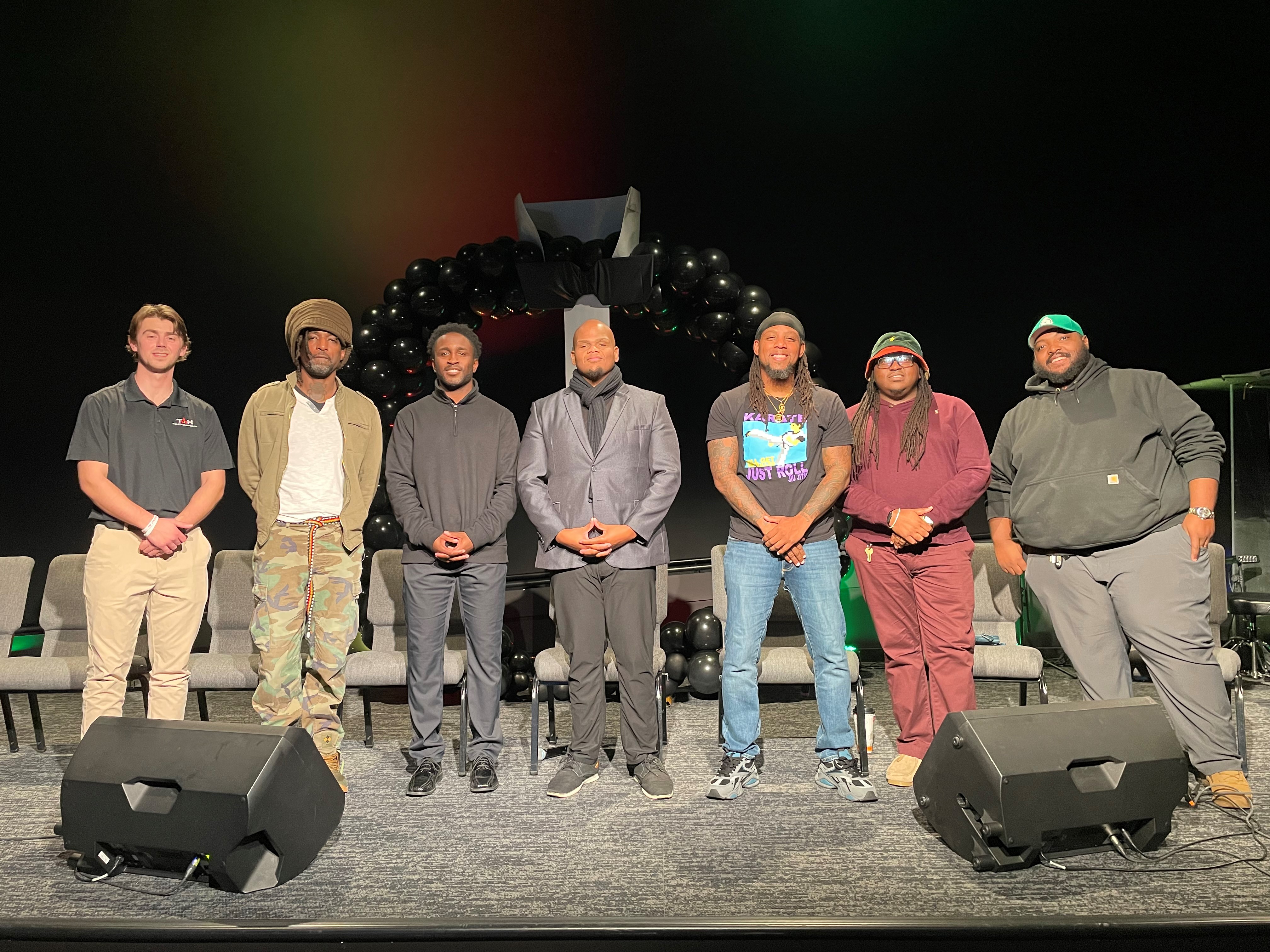 CVI Outreach Worker Marques (3rd from right) stands among panelists at the Empower Him conference in Dec. 2025.