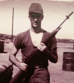 Joseph Gasperetti holding a rifle during the war