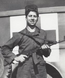 Gerald Milder holding a rifle wearing his Air Corps uniform