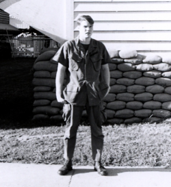 Gregory Strub standing outside a house wearing his military uniform