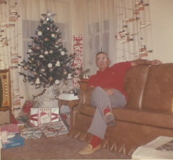 Robert Marechal years later on Christmas sitting on a couch in front of the tree