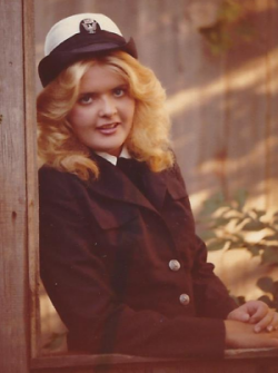 Robin Jett leaning against a window in her Navy uniform